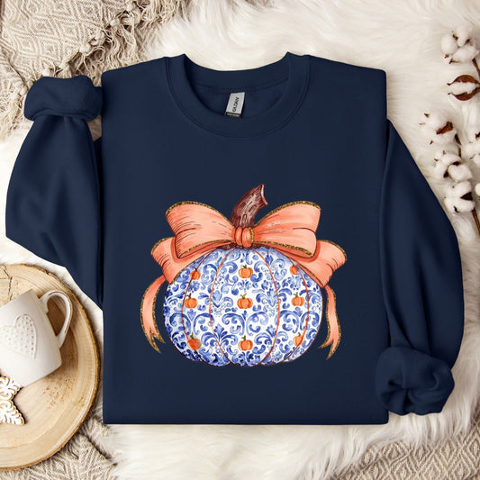 Navy sweatshirt featuring a blue and white chinoiserie pumpkin design with a peach bow accent.